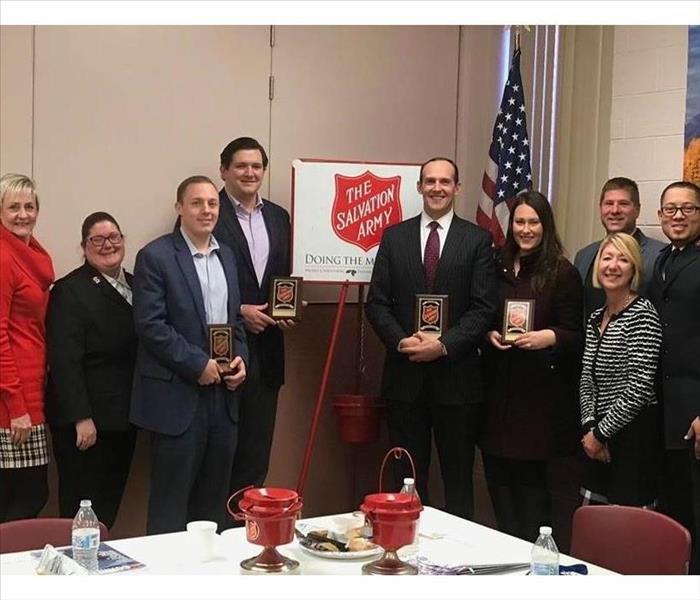 Salvation Army Advisory Board in front of Red Salvation Army Logo and Red Kettle