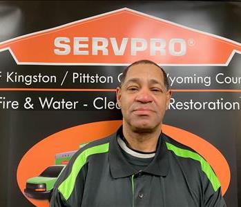 Male Production Technician in front of SERVPRO black and orange pop up sign