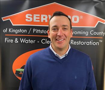 Male SERVPRO rep in front of pop up sign 