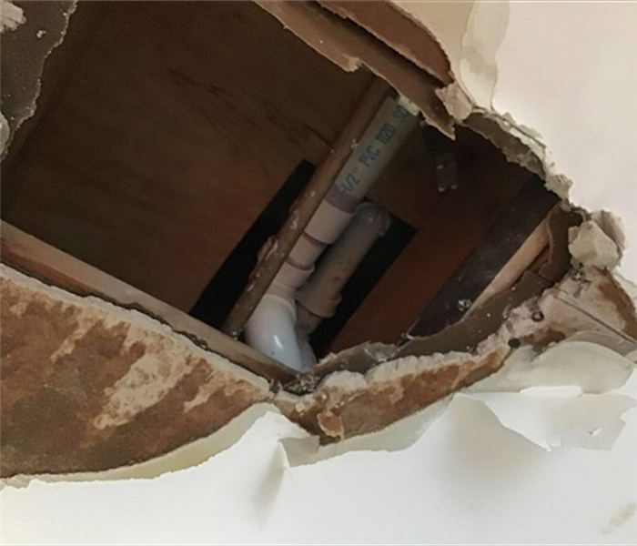 Ceiling Tiles with hole and damage in them from a burst pipe