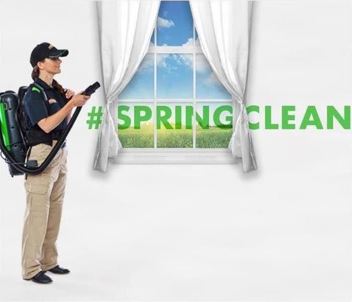 SERVPRO tech cleaning curtains with Spring Clean text